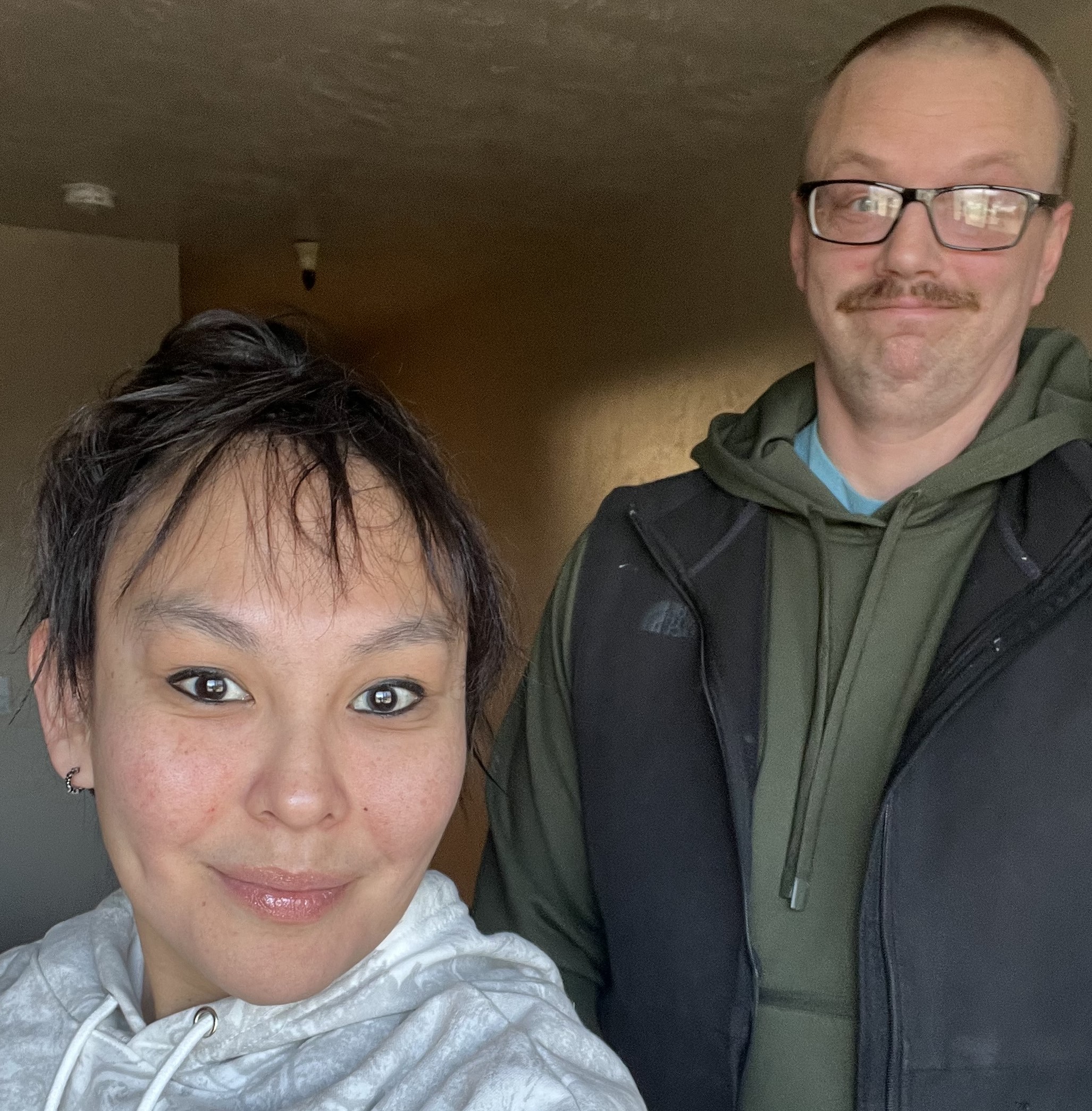 Nicole and Josh Bowen standing beside their yellow taxi van in Angoon, Alaska